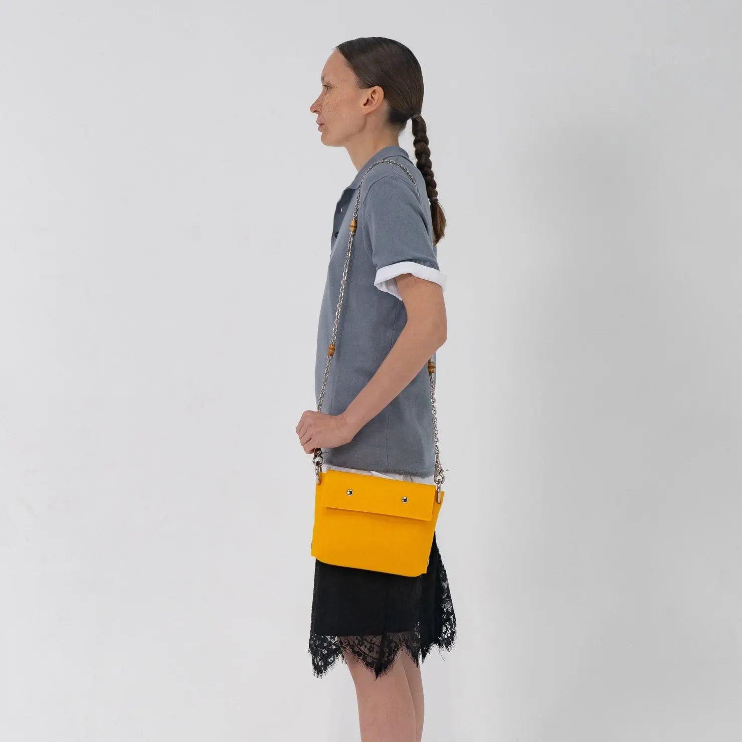 Person holding a yellow bag against a white background