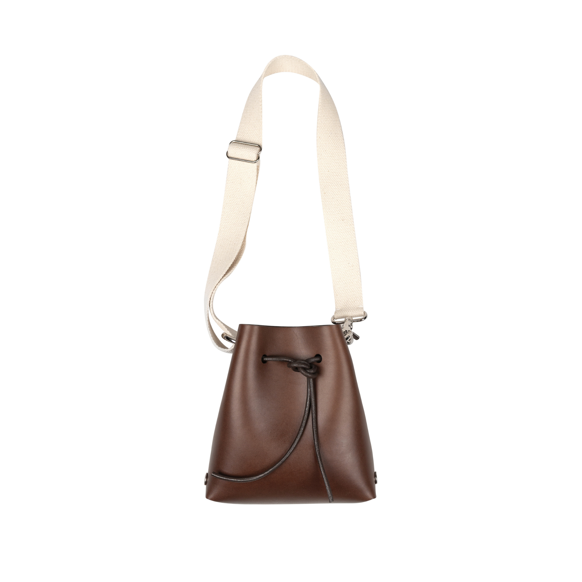 A brown leather bucket bag with an adjustable cream canvas shoulder strap and a black drawstring closure, shown against a plain white background.