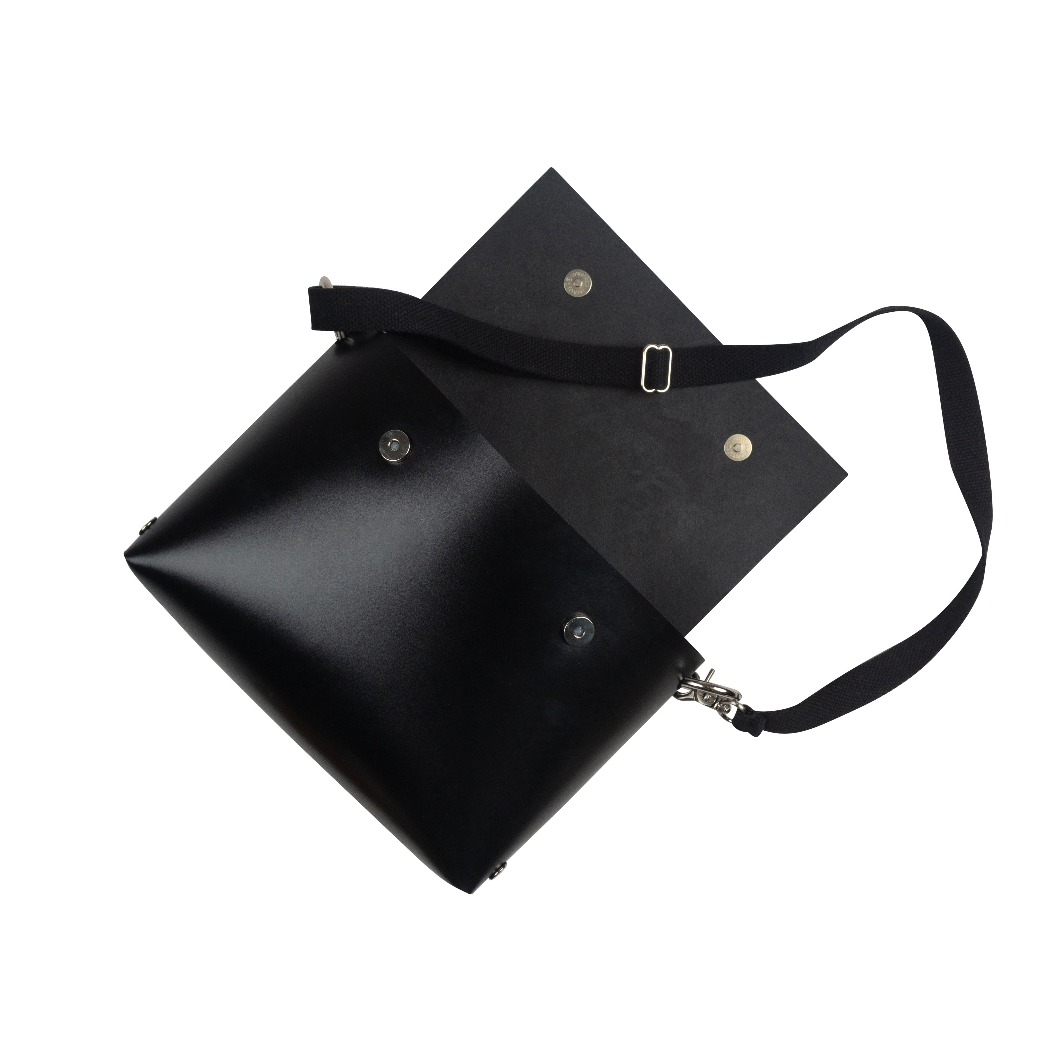Black leather handbag with a strap on a white background